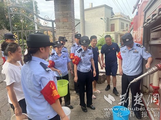 民輔警跟隨消防水車作業(yè)，通過肩挑手提的方式將清水送入行動不便的老年、殘障村民的家中（通訊員 李麗君 攝） (3).jpg.jpg