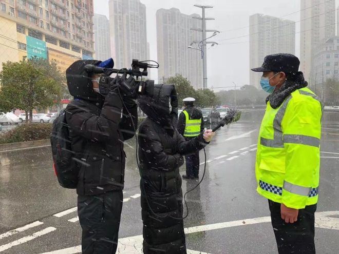 孝感市融媒體中心楊亞玲（風(fēng)雪中，采訪疫情期間重返一線的退休警察）_副本.jpg.jpg